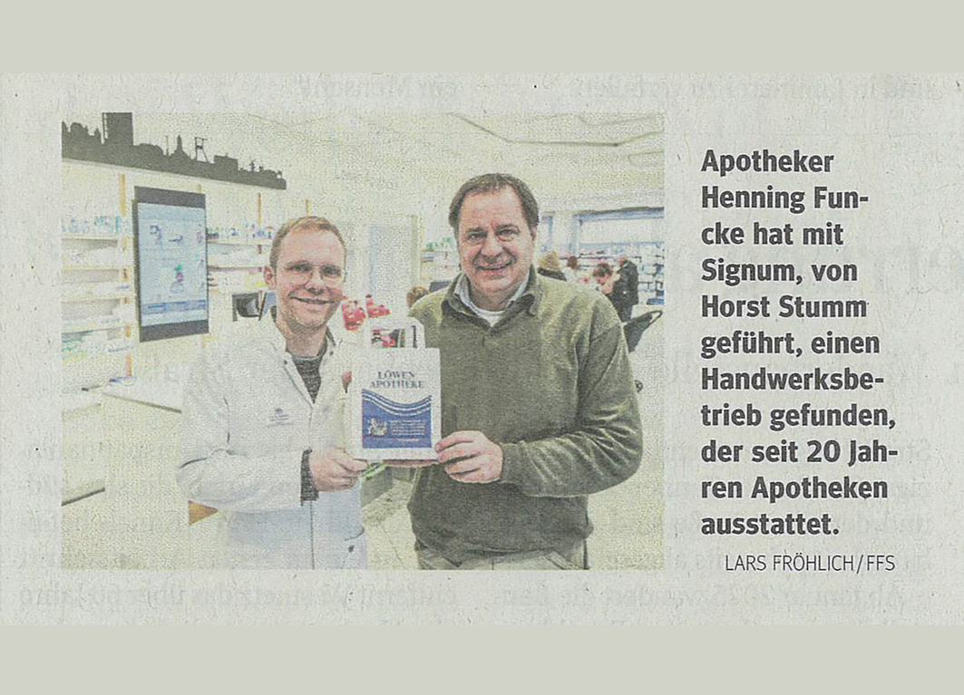 Zeitungsartikel über Apothekenumbau mit Foto, das Apotheker und Firmeninhaber in der neuen Apotheke zeigen.