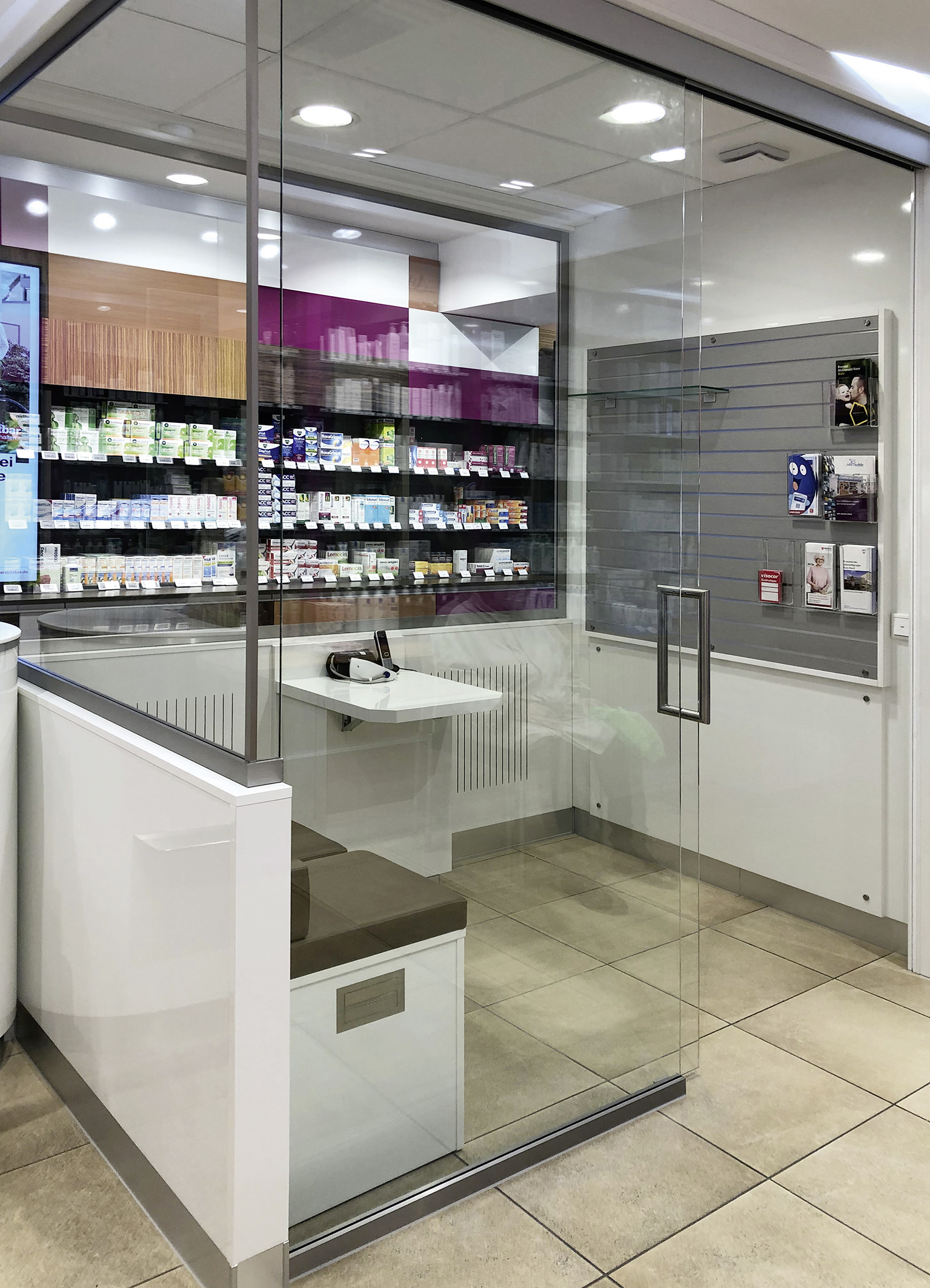 Ein Warteraum mit Sitzmöglichkeit und Glastür.