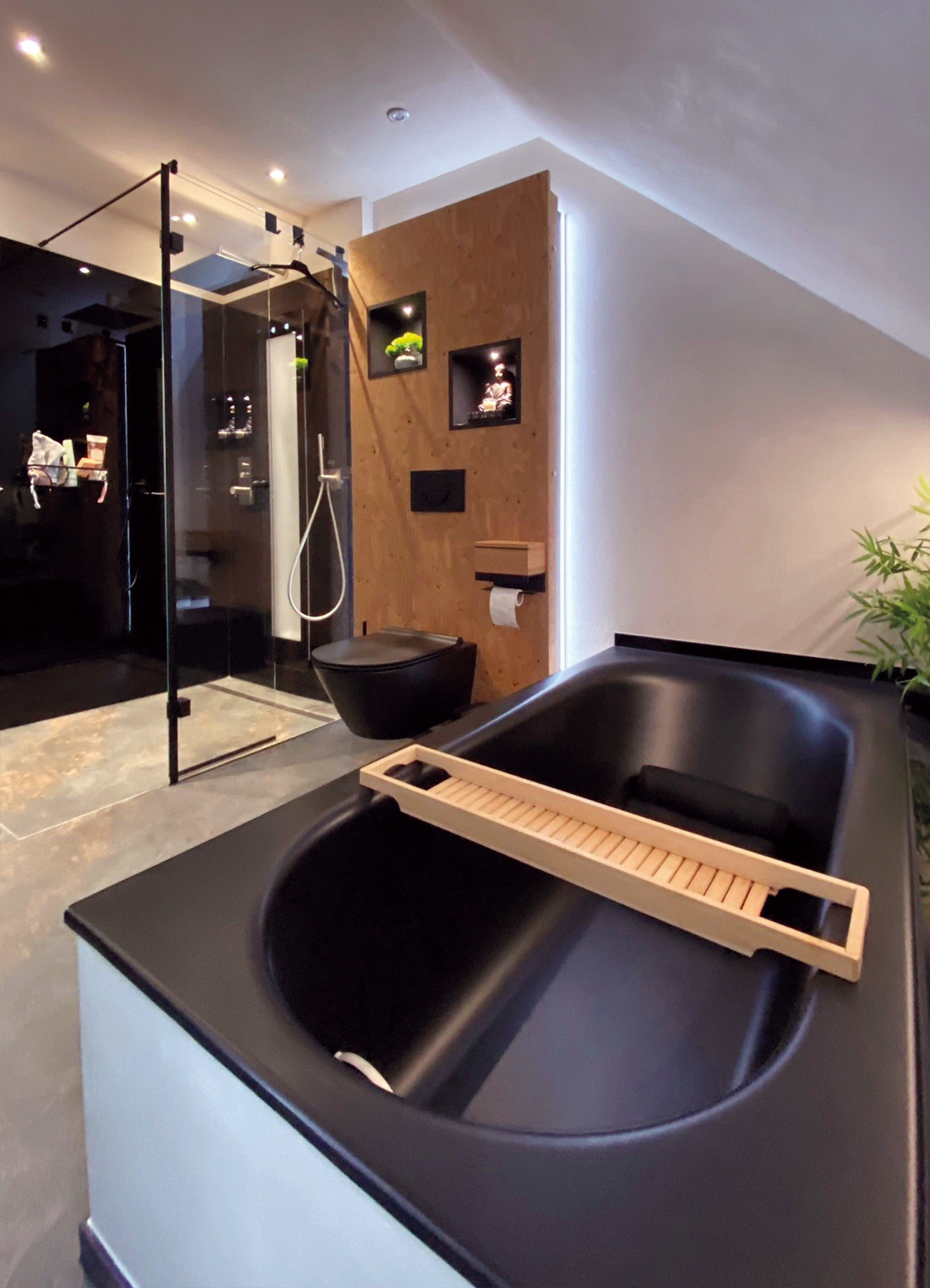 Perspektivische Ansicht eines Badezimmers mit WC, Dusche und Badewanne in schwarz und hinterleuchteter Wand in Holz.