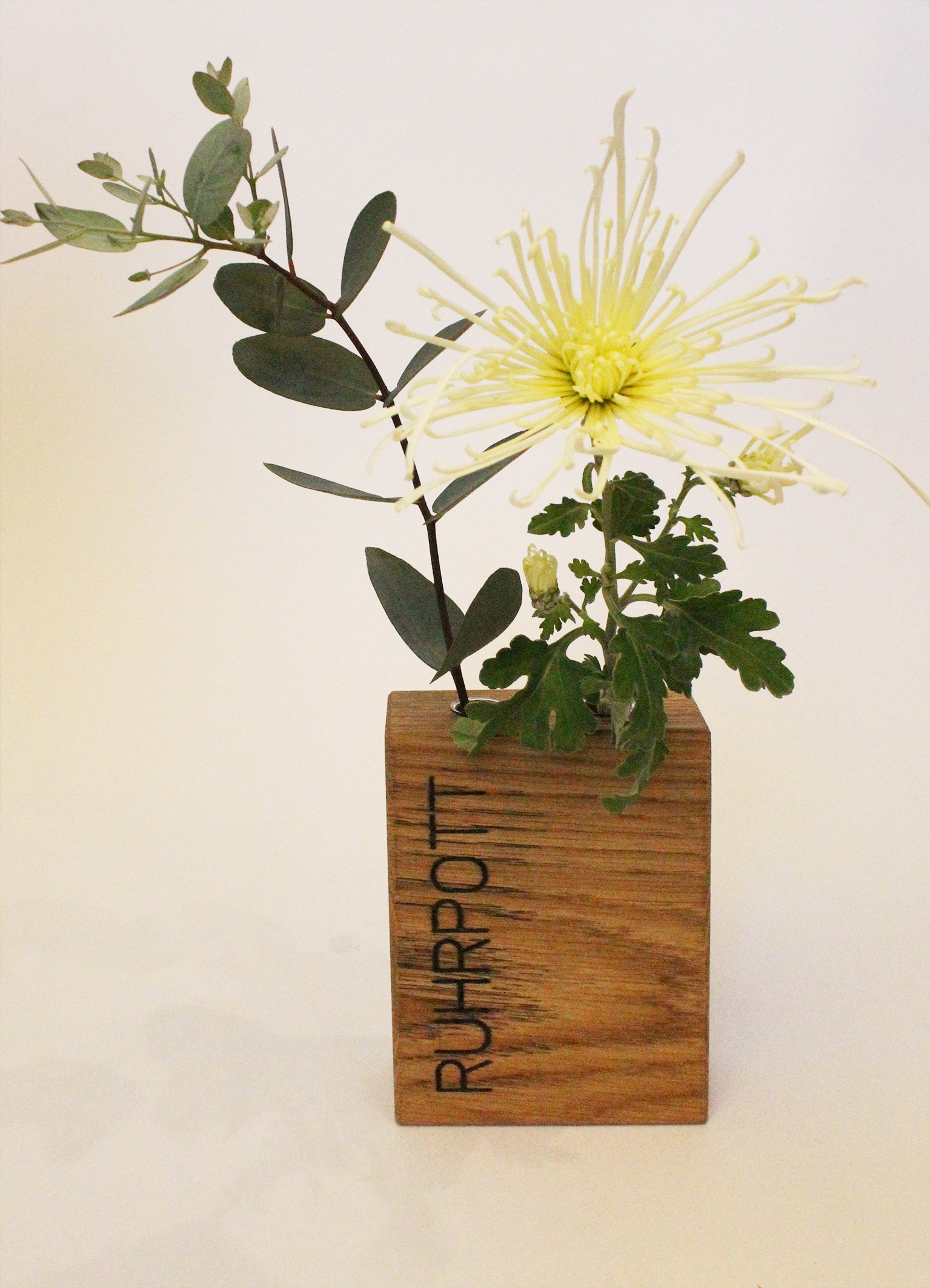 Holzvase mit 2 Glasröhrchen und Schriftzug "Ruhrpott" frontal fotografiert.