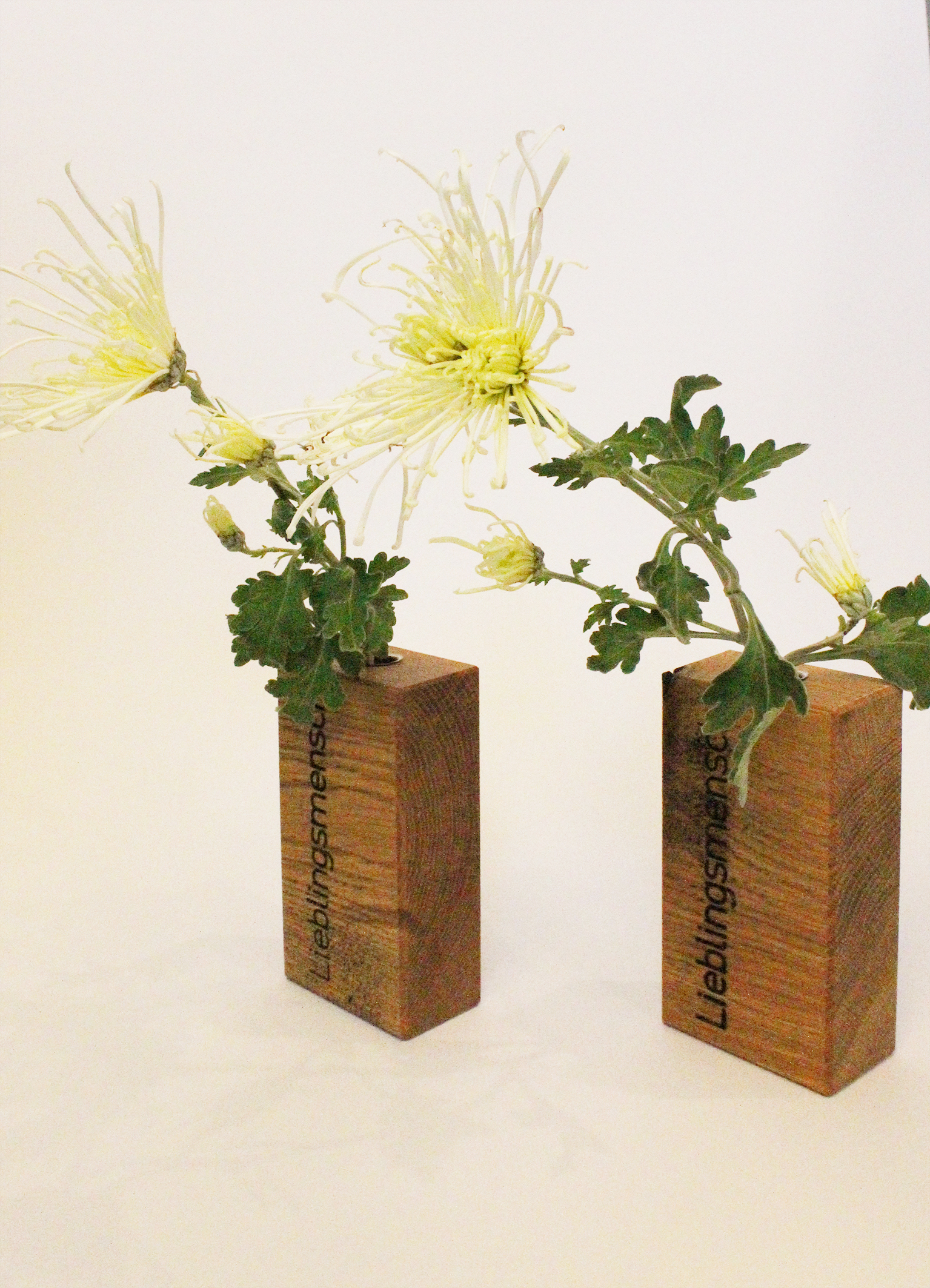 Holzvasen "Lieblingsmensch" mit je einem Glasröhrchen.