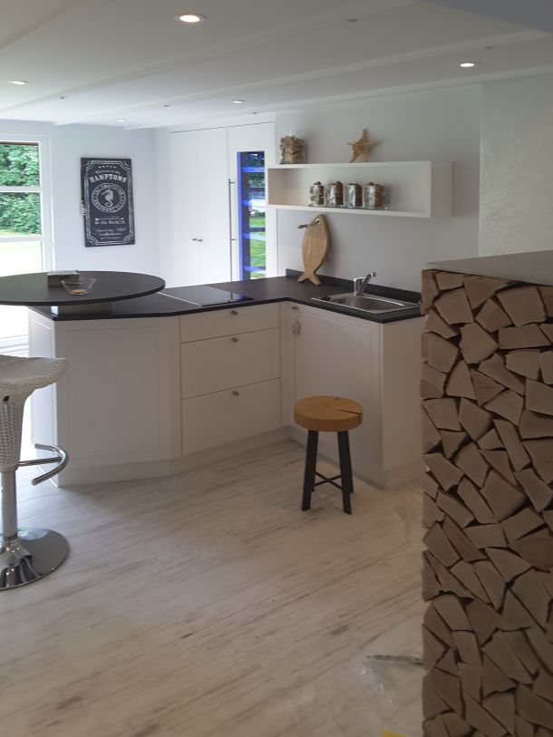 Eine moderne Küche mit einer Kommode aus gestapeltem Feuerholz.