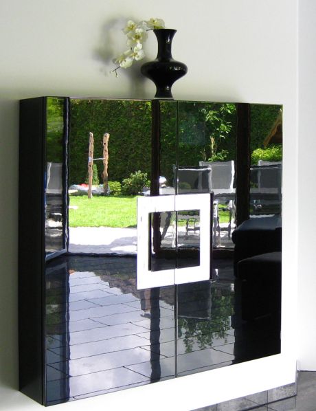 Ein Hängeschrank in geringer Tiefe in schwarz Hochglanz lackiert mit Griffdetail in Blattsilber und dekorativer Vase darauf.