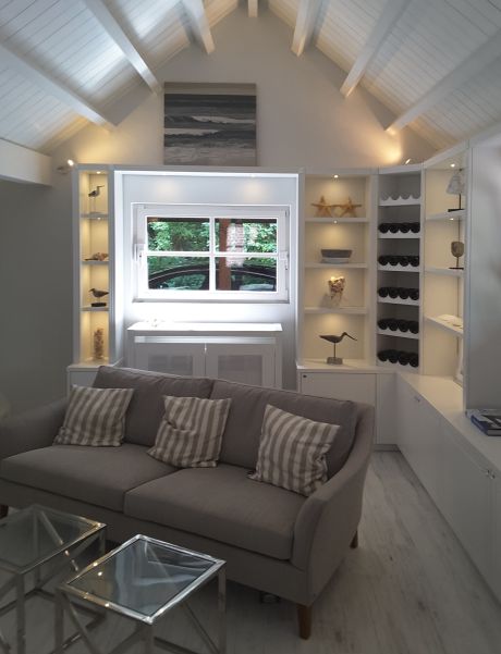 Ein modernes Dachboden-Wohnzimmer mit Couch , Wandschrank und Fenster.