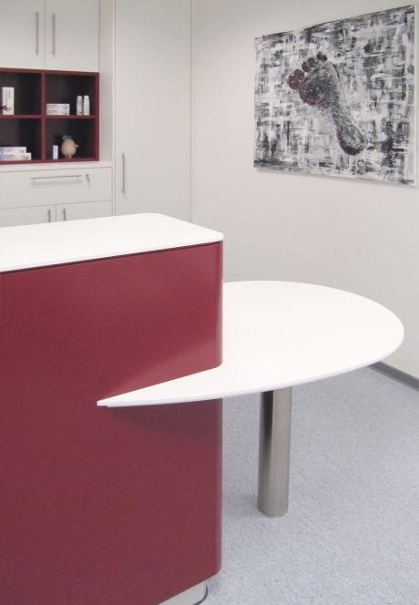 Ein modernes Beratungszimmer mit Theke und integriertem, runden Beratungstisch.