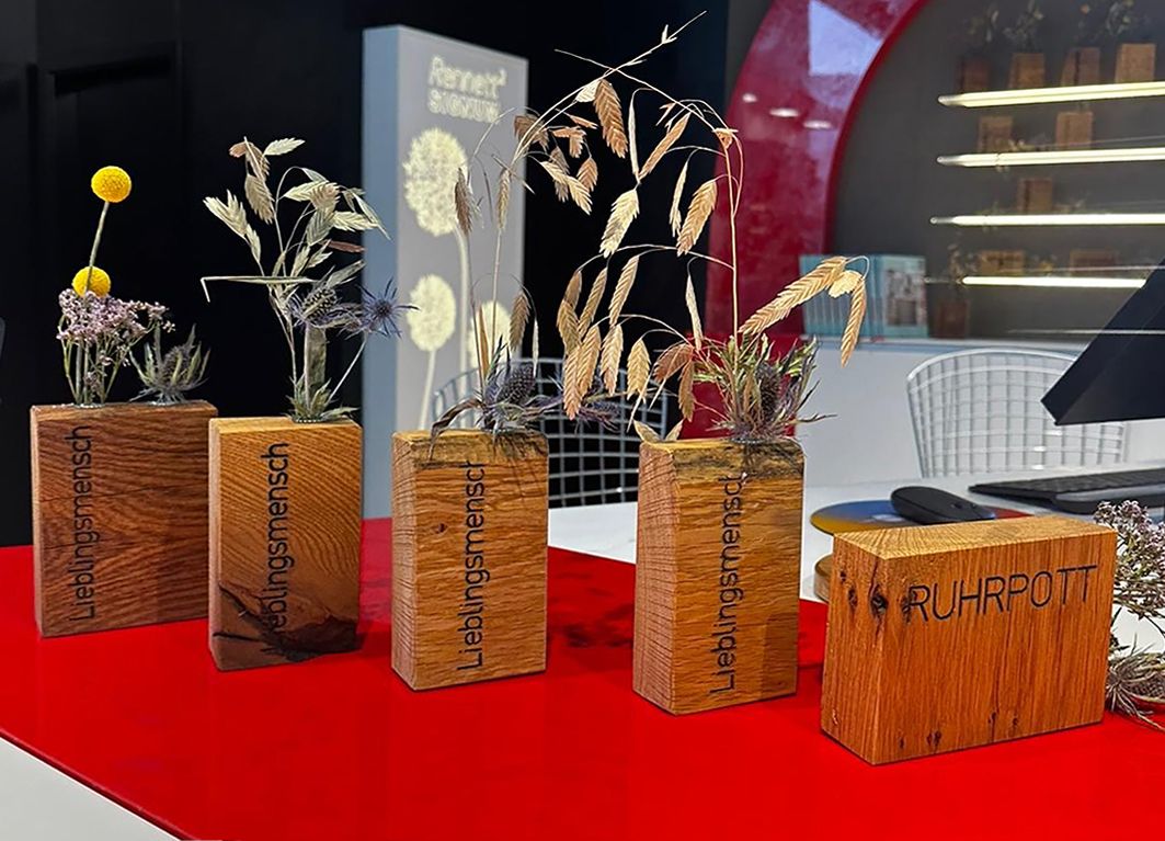 Holzvasen auf rotem Untergrund mit eingefrästen Schriftzügen "Lieblingsmensch" und "Ruhrpott".