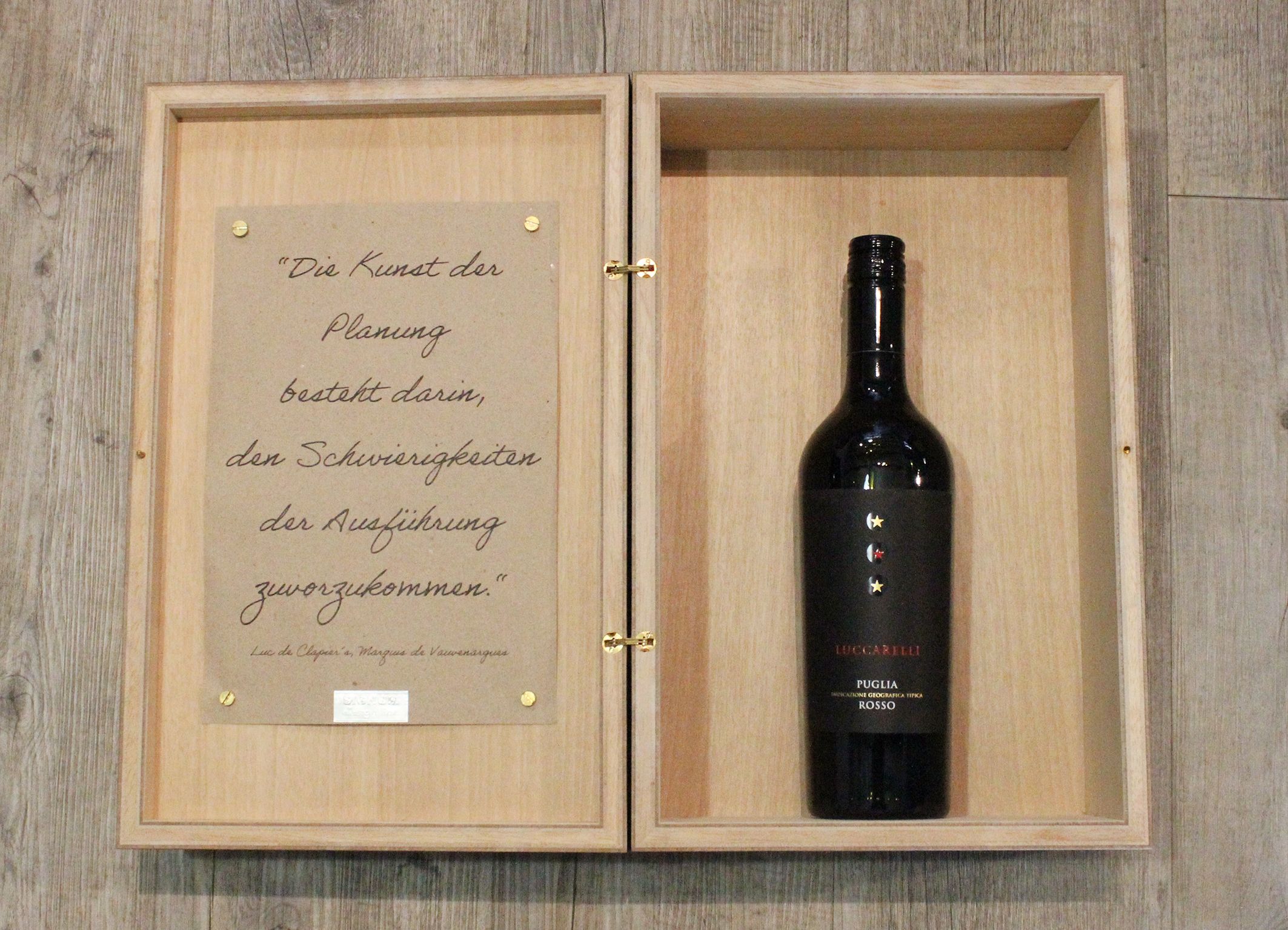 Weinkiste Makasssar geöffnet mit Spruch: "Die Kunst der Planung...".