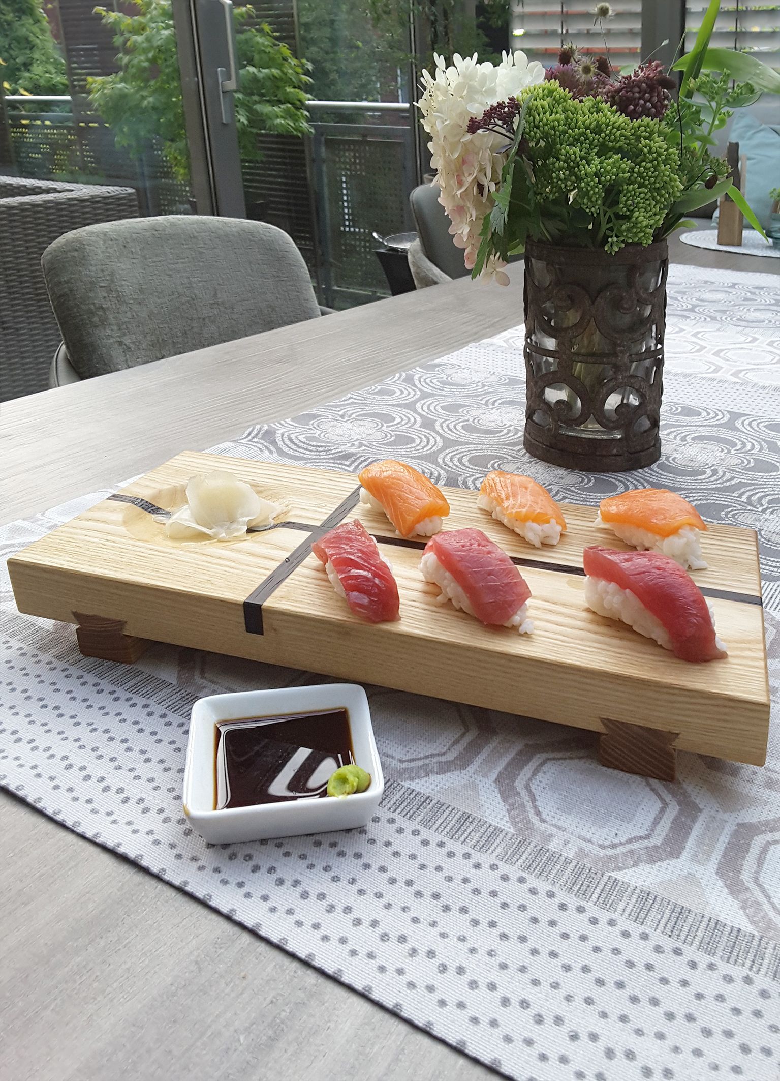 Japanisches Sushi Brett bestückt mit Sushi, Wasabi Sojasauce in Schälchen.