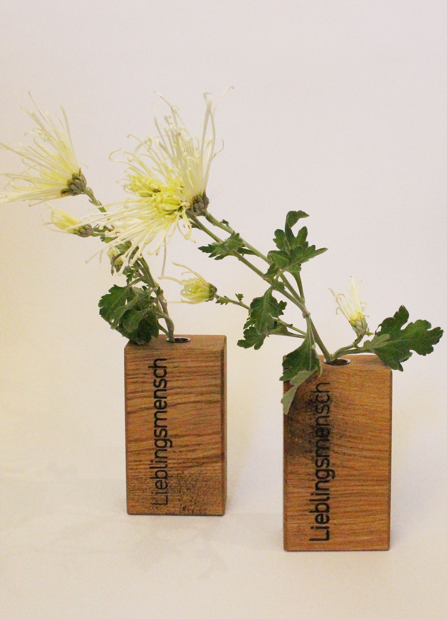 Holvasen "Lieblingsmensch" mit je einem Glasröhrchen.