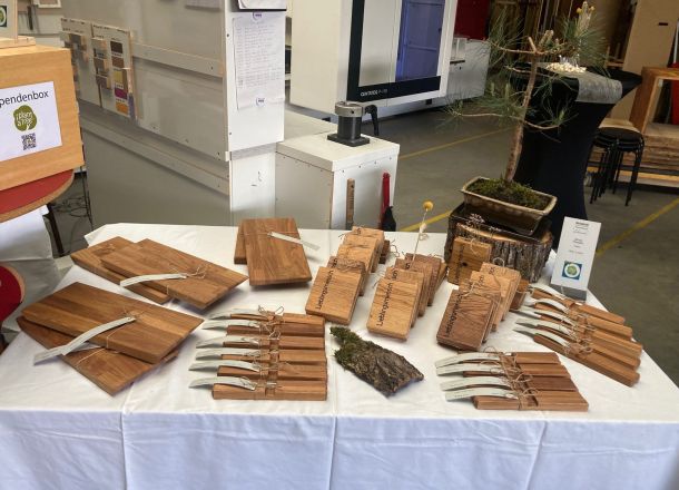 Tisch mit Holzbrettchen, Holzvasen, Holzuntersetzern und Bonsai.