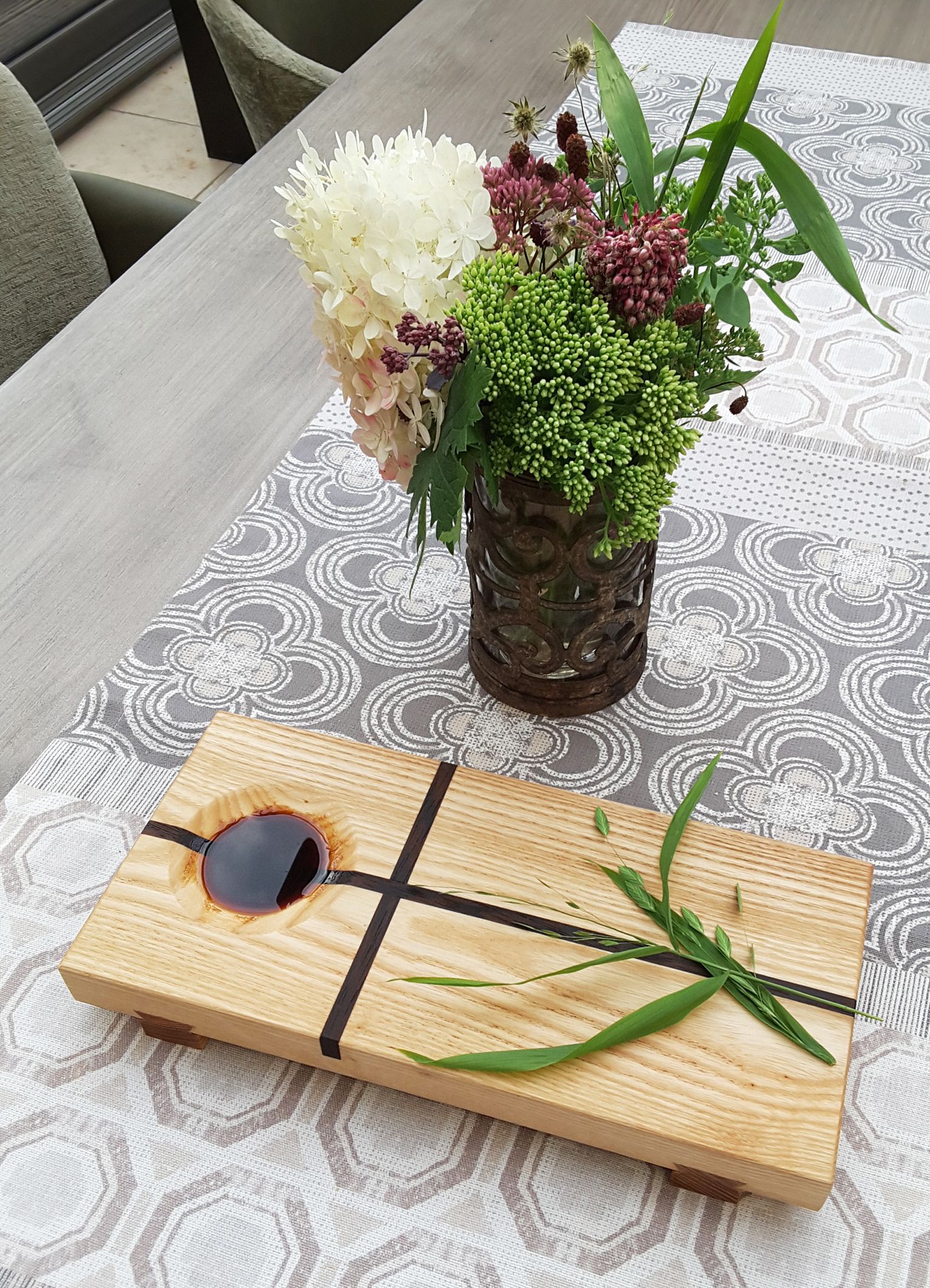 Sojasaucenbrettchen mit Dekozweig und Sojasauce in gefräster Mulde.