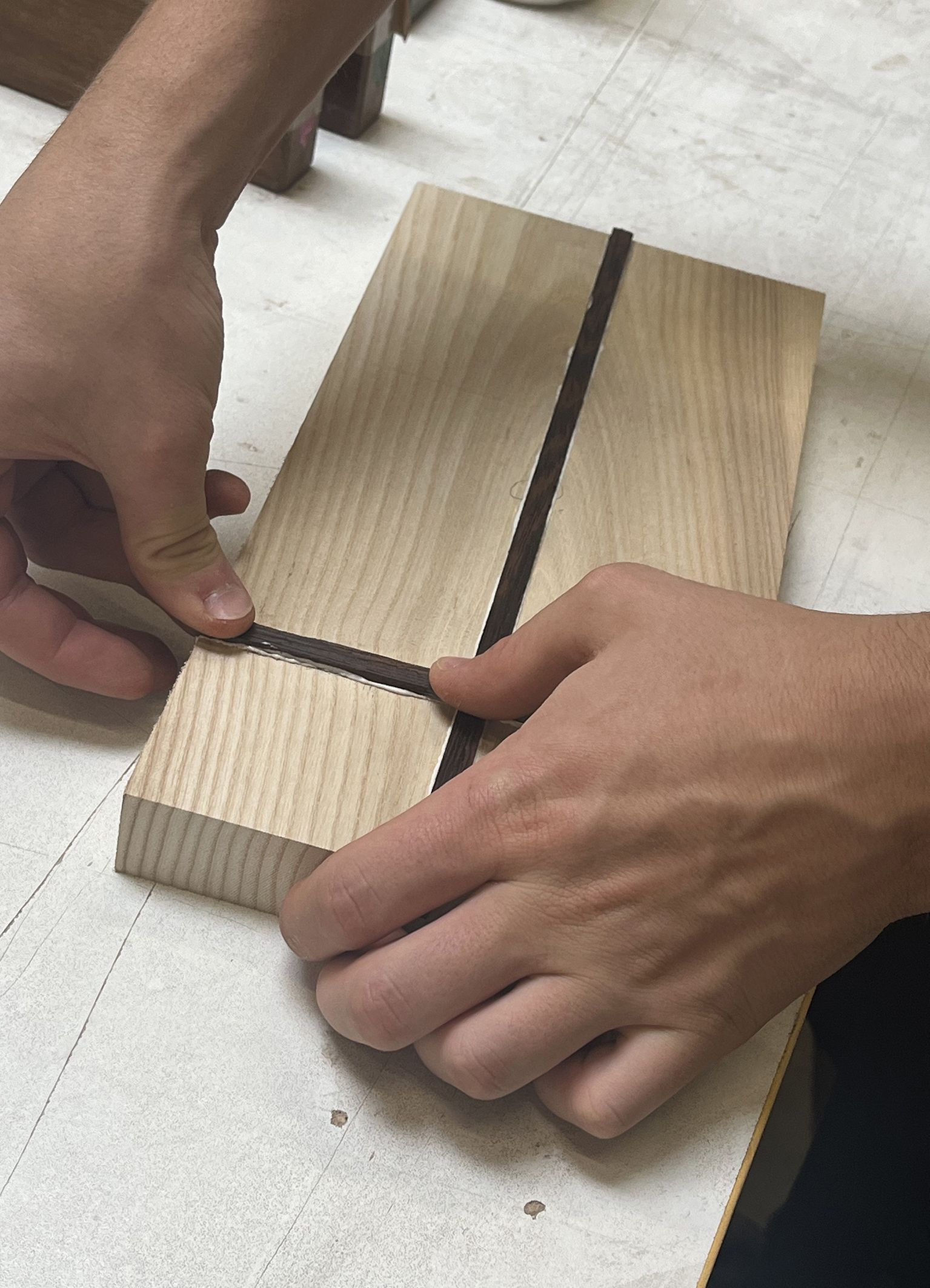 Japanisches Sushi Brett, bei dem Kontrastleisten eingeleimt werden.