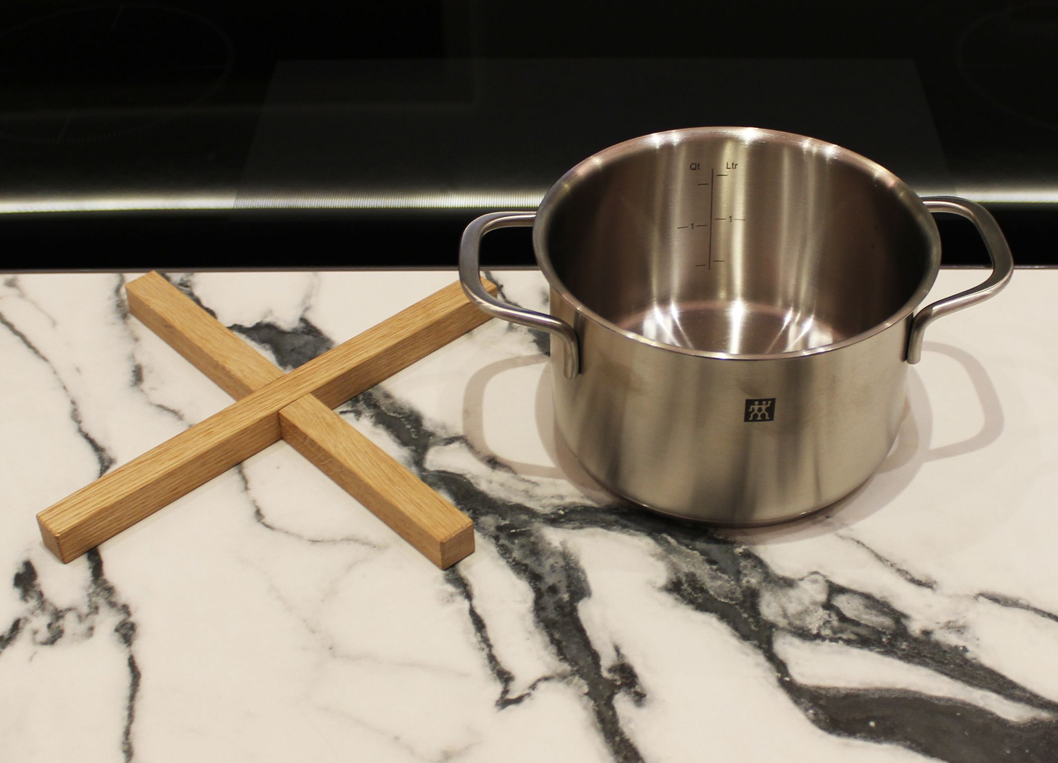 Holzkreuz in Eiche mit Topf daneben.