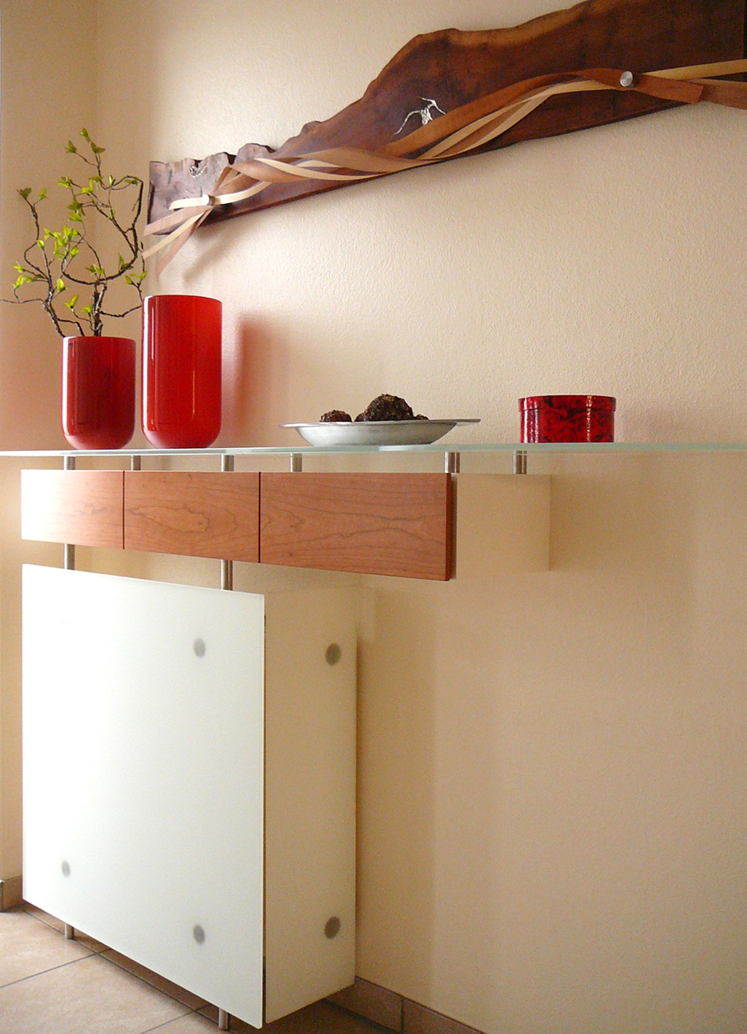 Heizkörperverkleidung in satiniertem Glas mit Schubladen und Glasablage darüber.